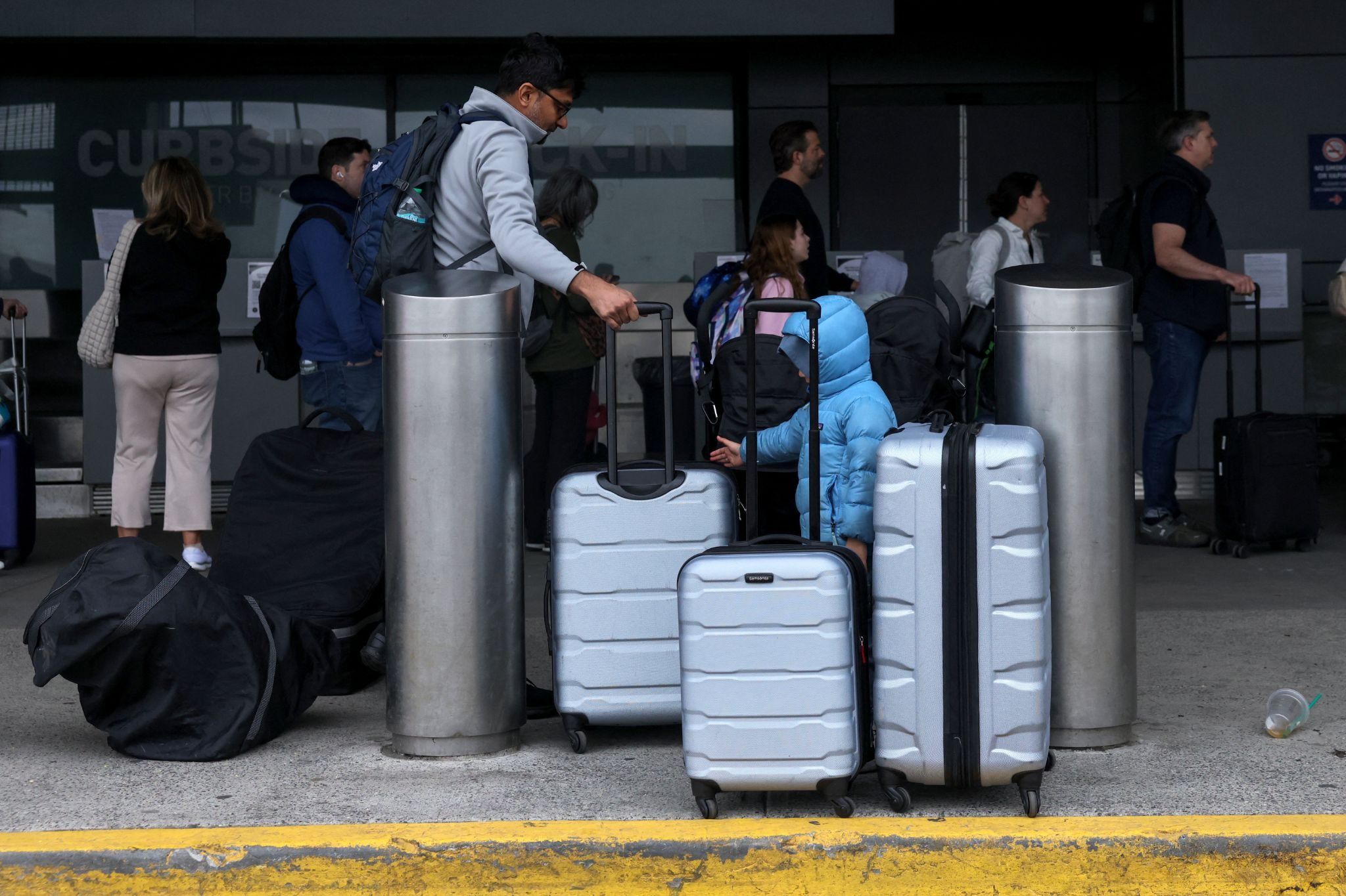 Travelers with suitcases arrive at airport
