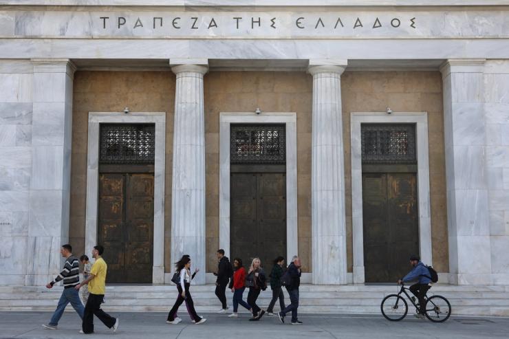 People walk in front of Bank of Greece in central Athens.