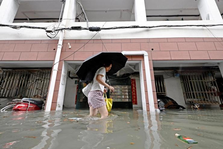 A resident wades through floodwaters at a residential compound following Typhoon Dolphin.