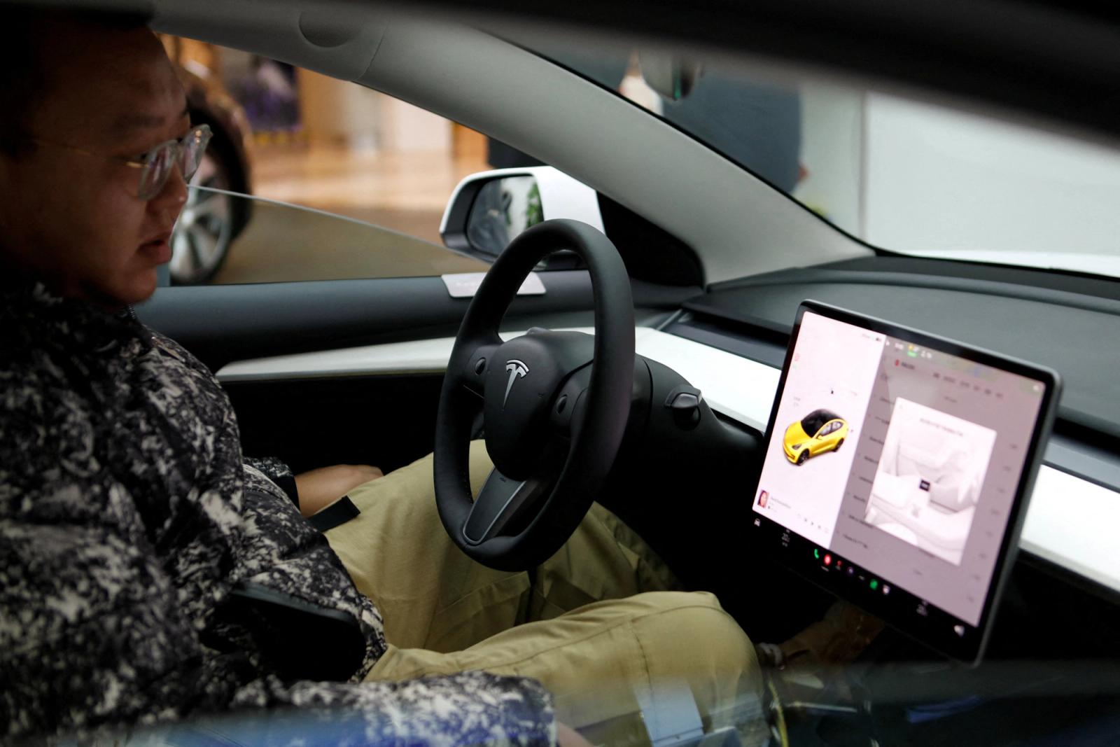 A visitor checks a Tesla Model 3 car at a showroom of the U.S. electric vehicle (EV) maker in Beijing, China February 4, 2023. 