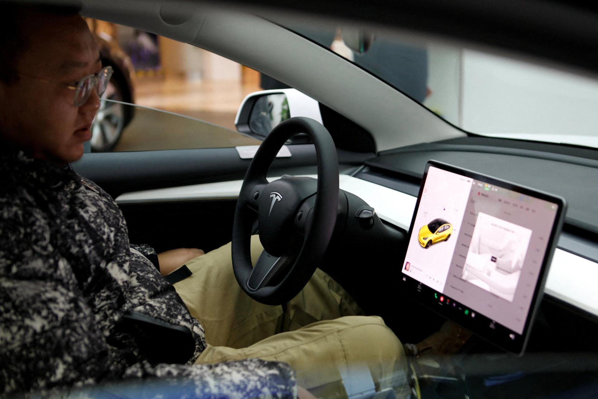 A visitor checks a Tesla Model 3 car at a showroom of the U.S. electric vehicle (EV) maker in Beijing, China February 4, 2023. 