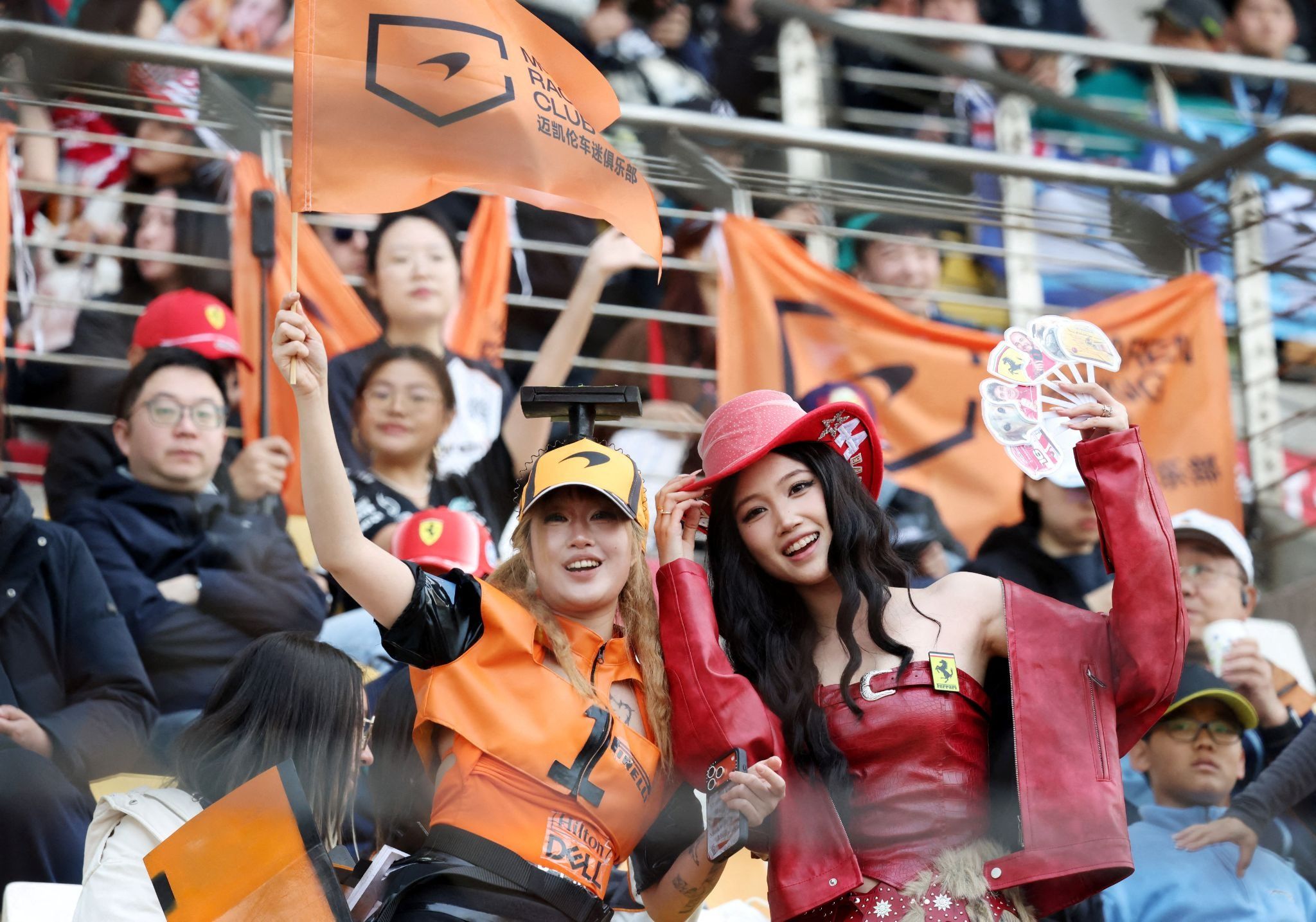 A McLaren and Ferrari fan poses for a photograph in the stands before the race