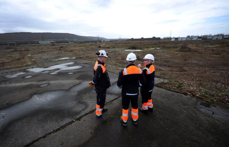 Sembcorp employees stand on a patch of disused land earmarked as a future site for a data center on the Wilton International site near Middlesbrough, Britain