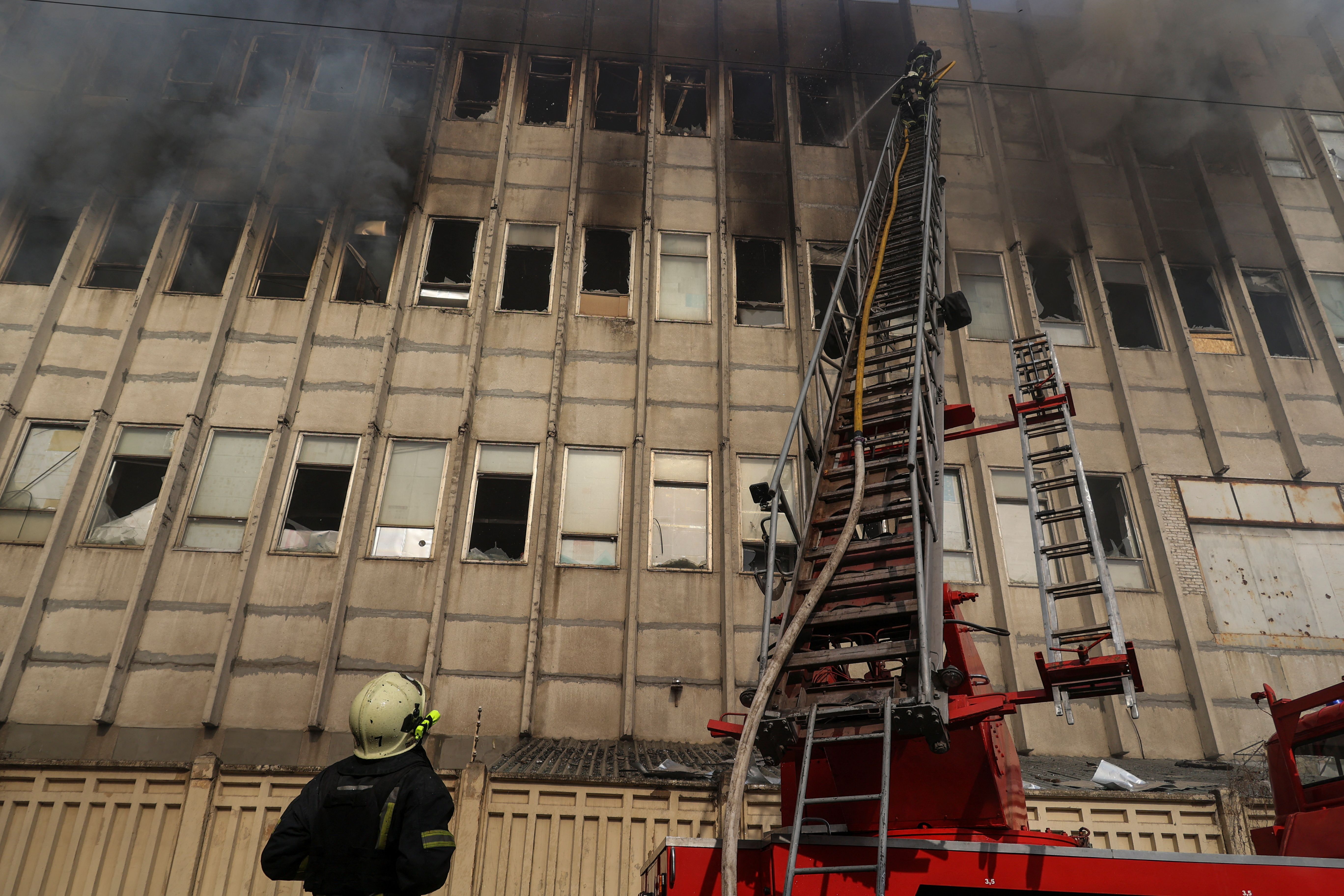 Firefighters work at the site of a Russian missile strike in Kharkiv