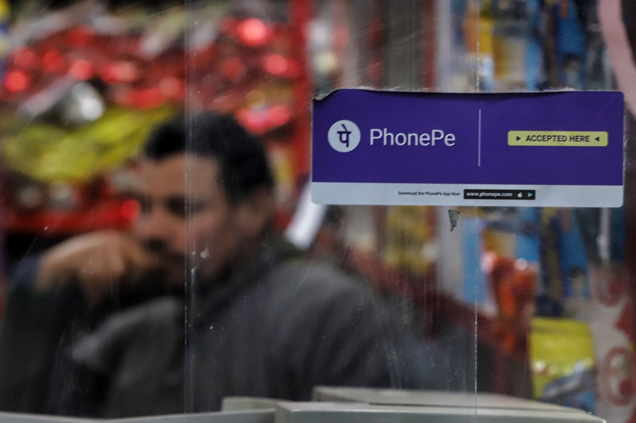 Photo of a PhonePe sticker on the glass of a grocery shop in India
