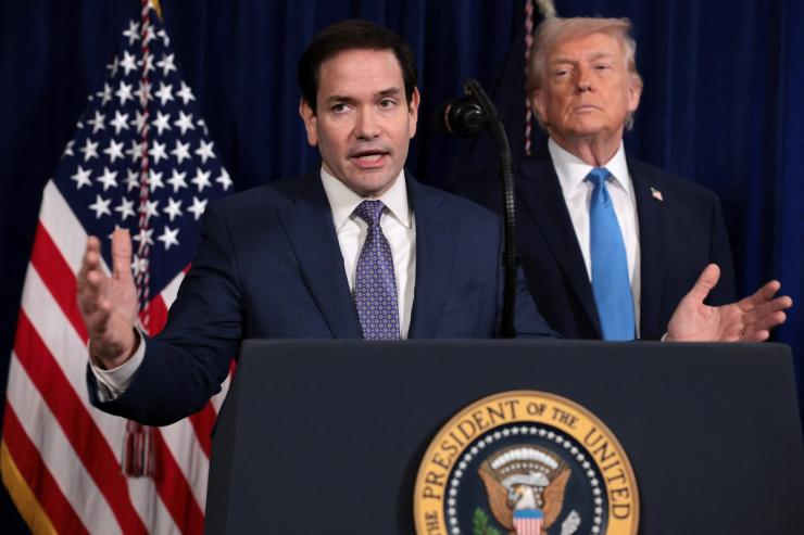 U.S. Secretary of State Marco Rubio speaks as U.S. President Donald Trump stands behind him during a press conference following a U.S. strike on Venezuela where President Nicolas Maduro and his wife, Cilia Flores, were captured, from Trump’s Mar-a-Lago club in Palm Beach