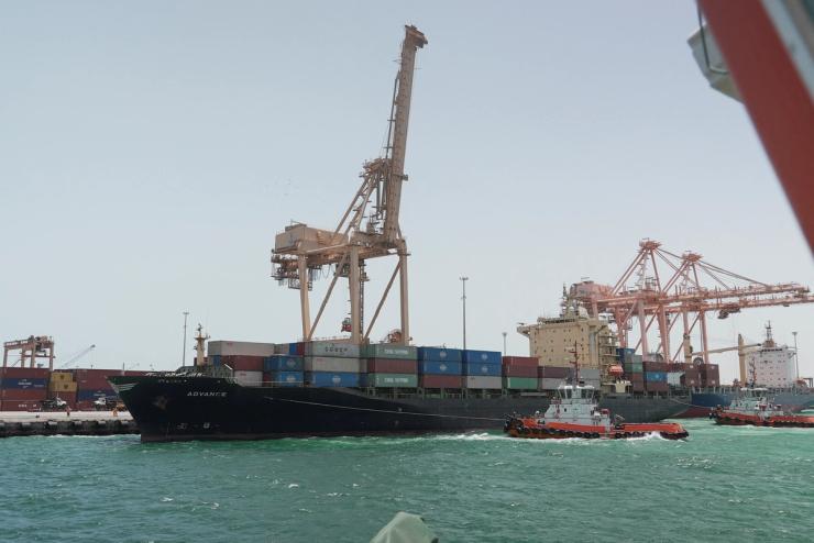 A tugboat assists a cargo ship to dock at the Dammam Port in Dammam.