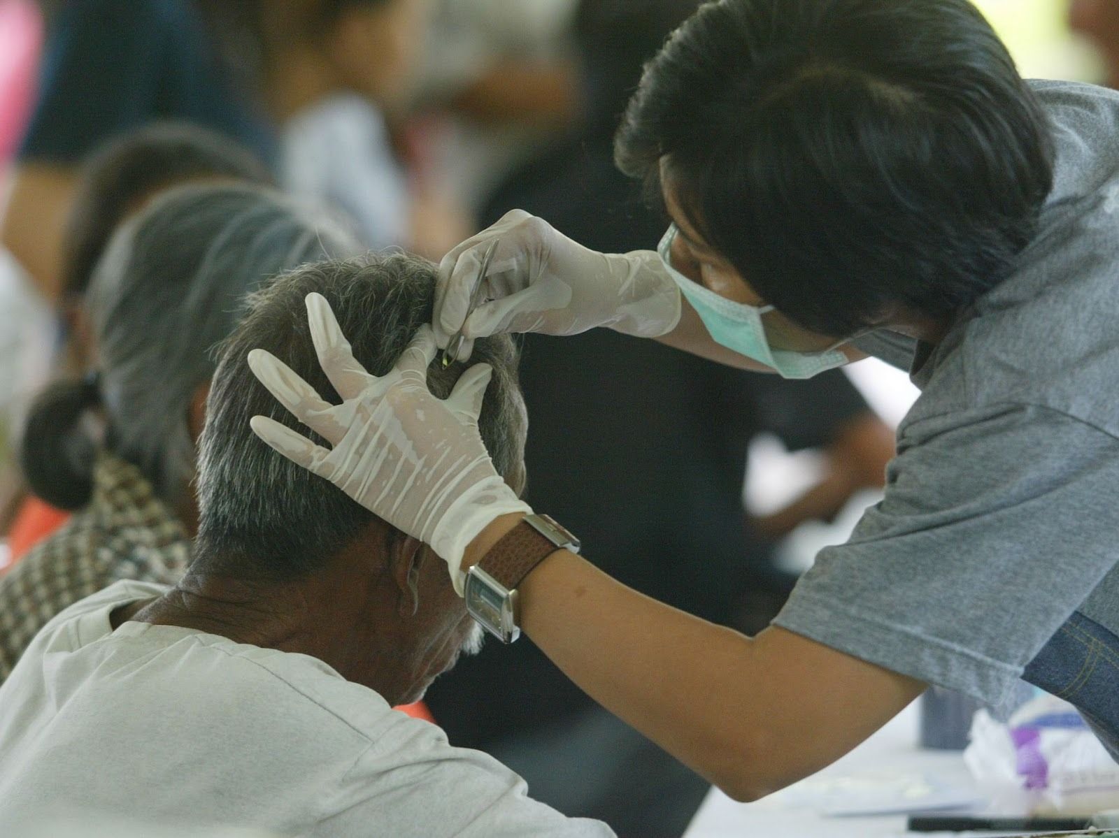 A medic taking a hair sample. 