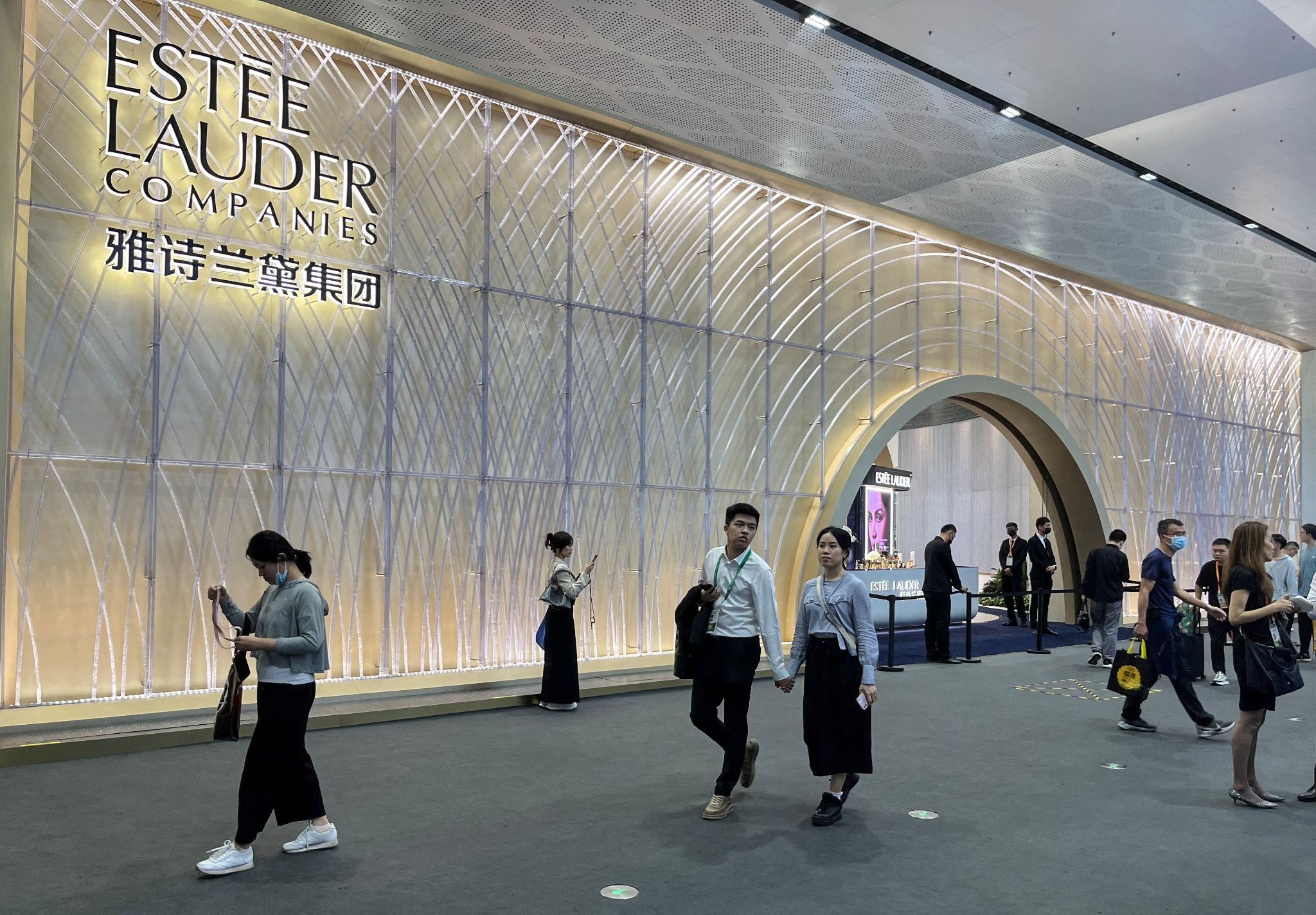 People walking past an Estée Lauder booth in Haikou, Hainan province in China 