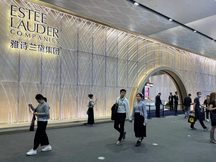 People walking past an Estée Lauder booth in Haikou, Hainan province in China