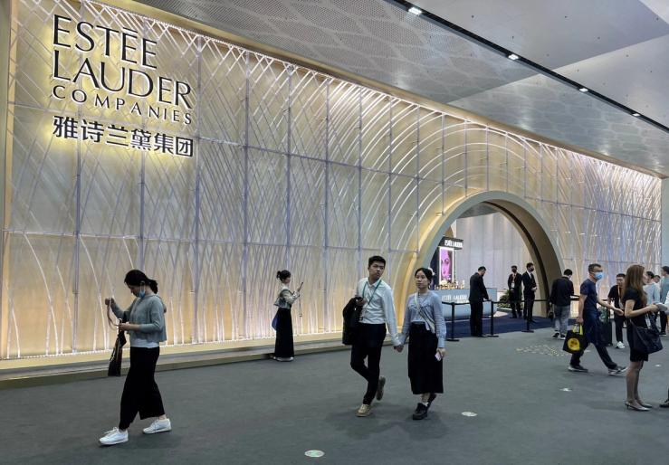 People walking past an Estée Lauder booth in Haikou, Hainan province in China