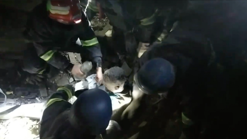 Emergency workers tend to a man in the rubble in Zaporizhzhia.