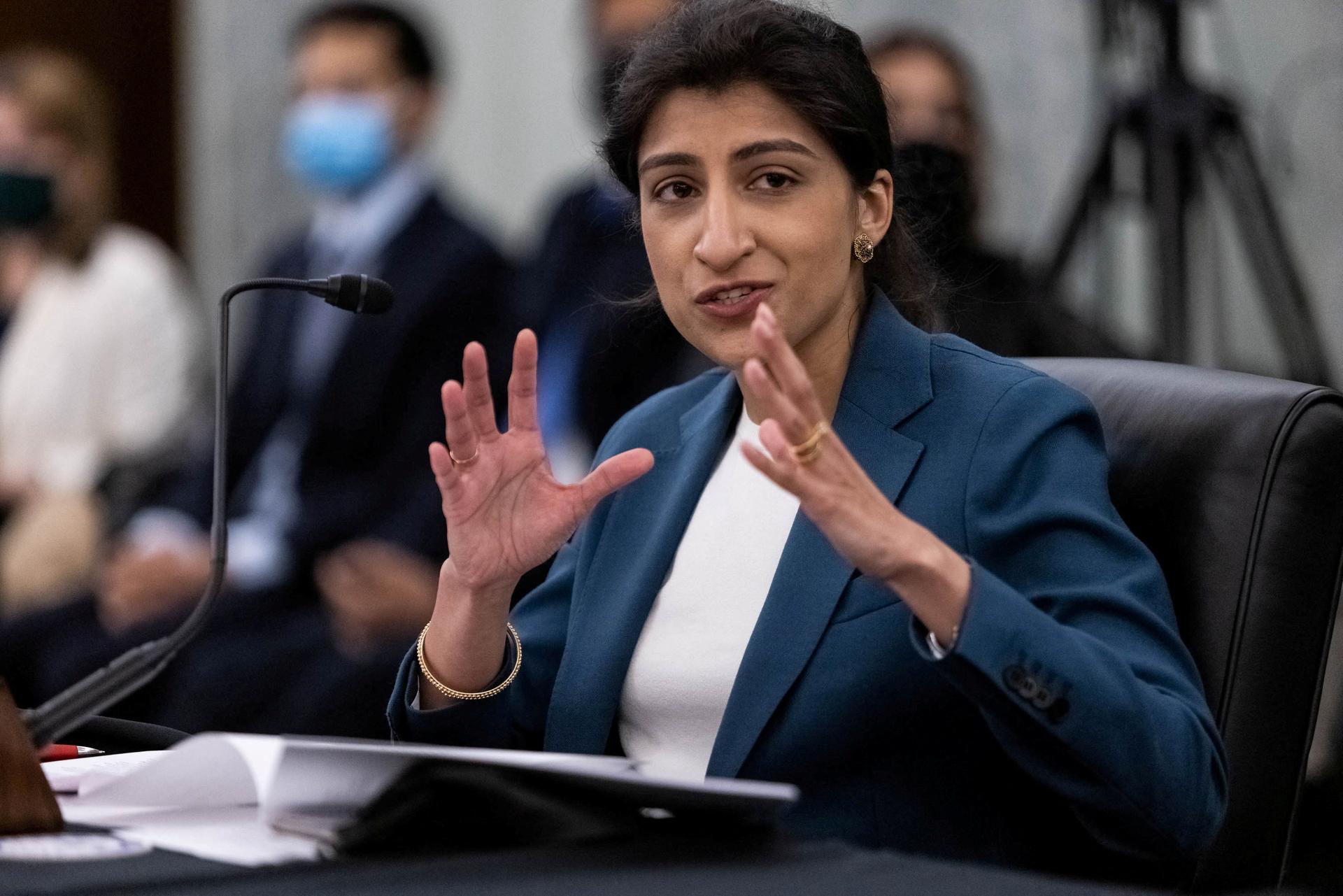 Lina Khan, wearing a blue blazer, testifies at a Senate Committee hearing on Capitol Hill, Washington