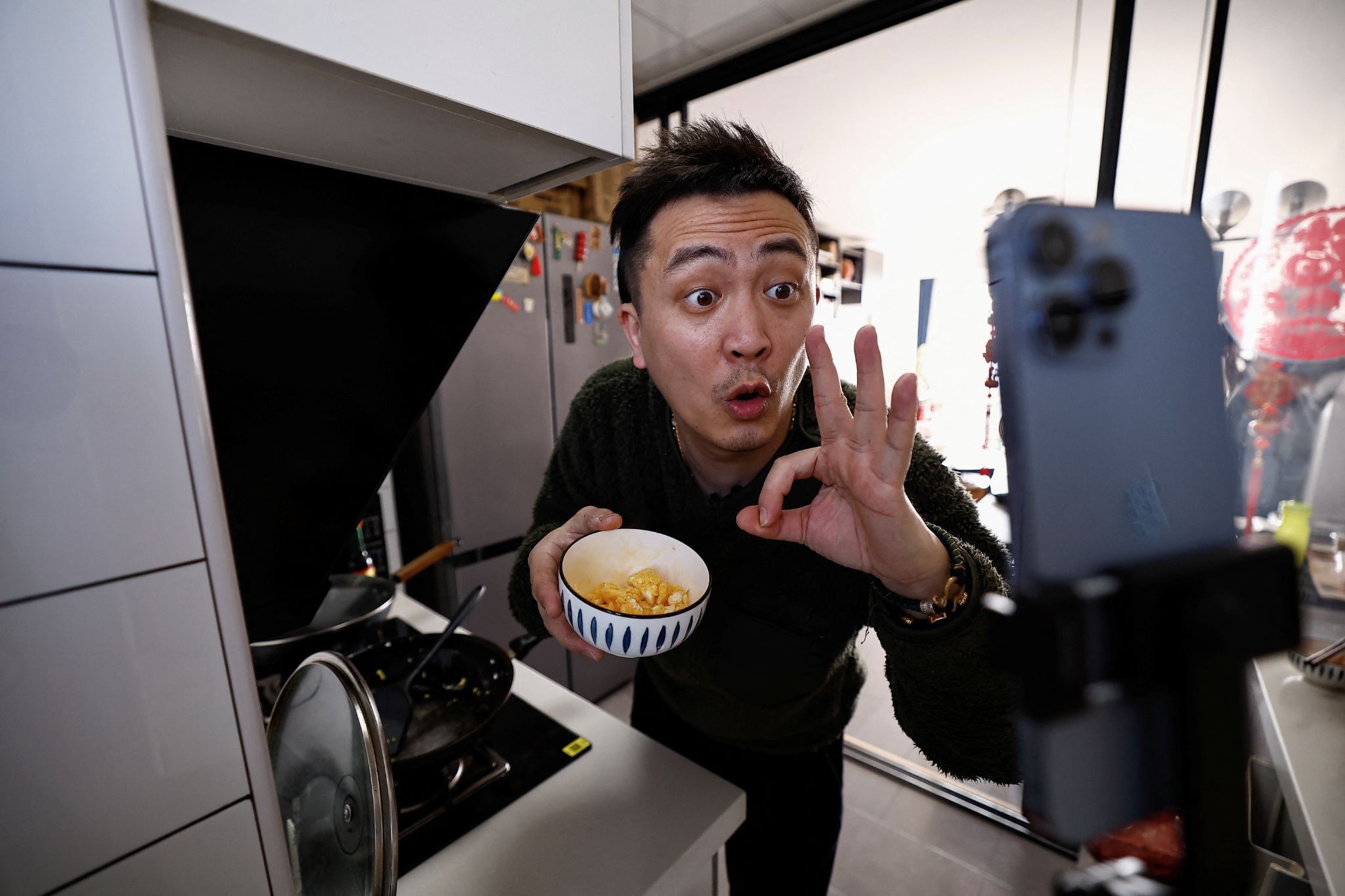 A Chinese influencer films a video in his kitchen