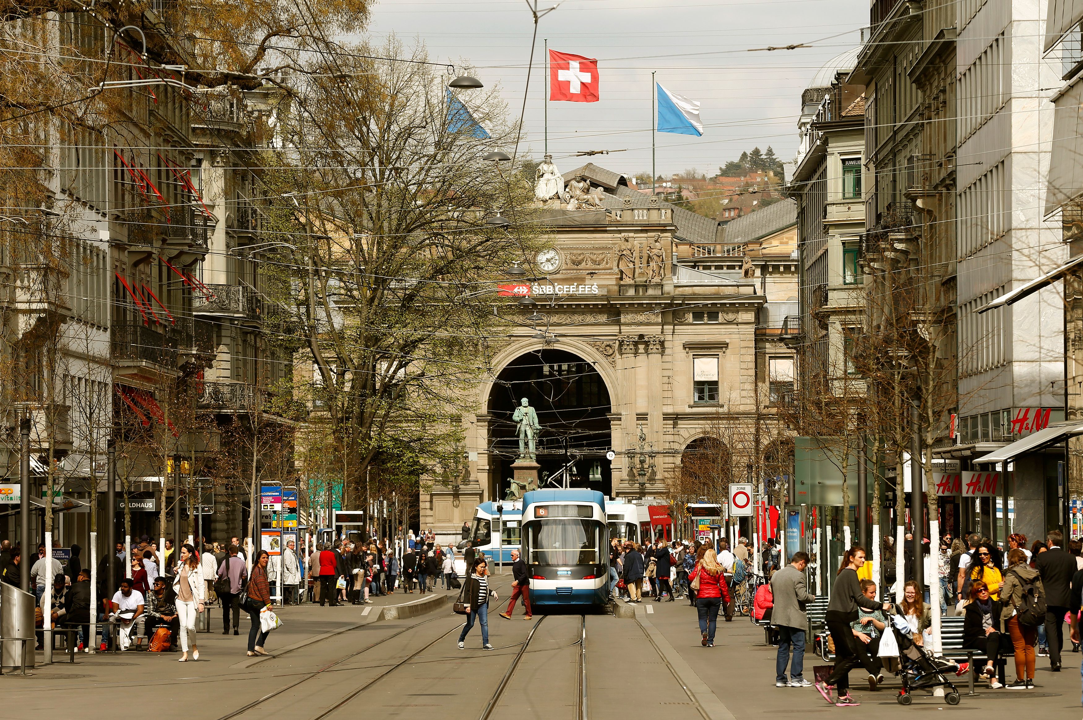 People walk in front of the Hauptbahnhof central railway station in Zurich