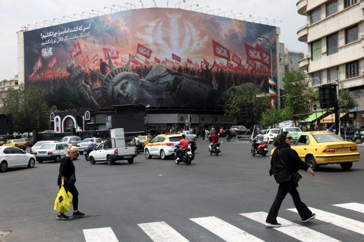 People walk past an anti-U.S. billboard on a street in Tehran, Iran.