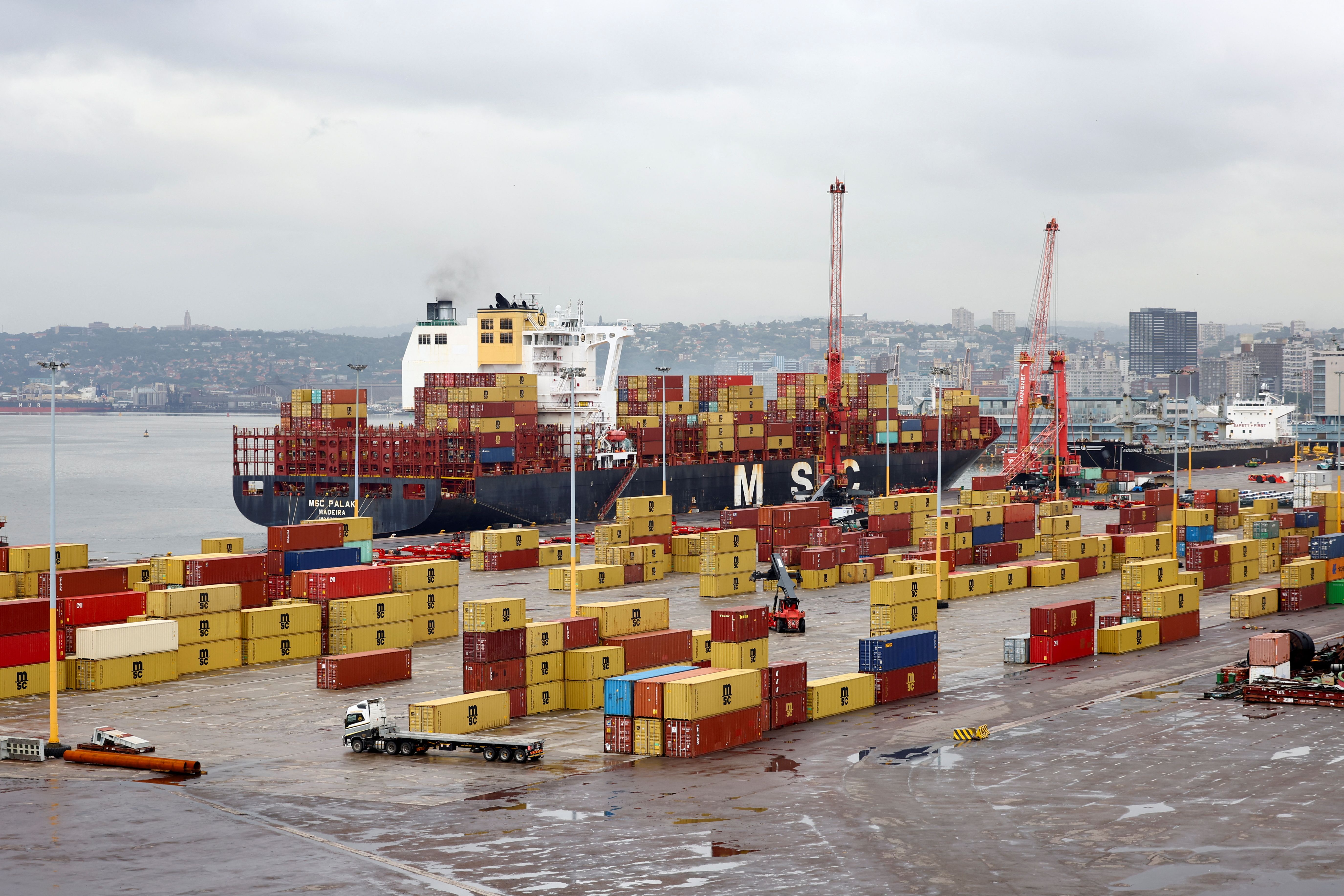 The MSC container ship is docked while a truck drives past containers at the Durban Harbour.