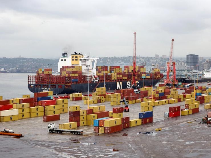 The MSC container ship is docked while a truck drives past containers at the Durban Harbour.
