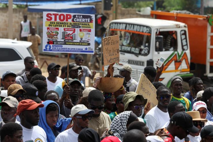 Protesters hold placards at a demonstration against the rising cost of living in Dakar, Senegal.
