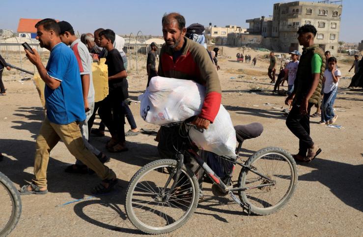 Palestinians wait to receive aid in Gaza.