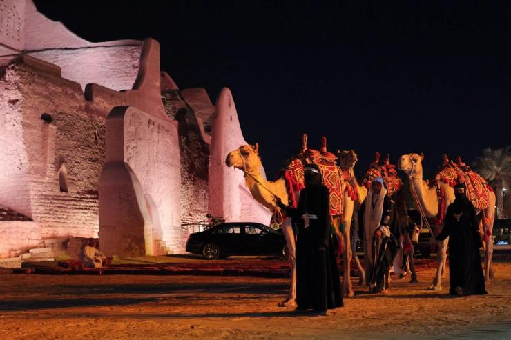 People stand with camels, on the day US President Donald Trump visits At-Turaif World Heritage Site, in Diriyah, Saudi Arabia, May 13