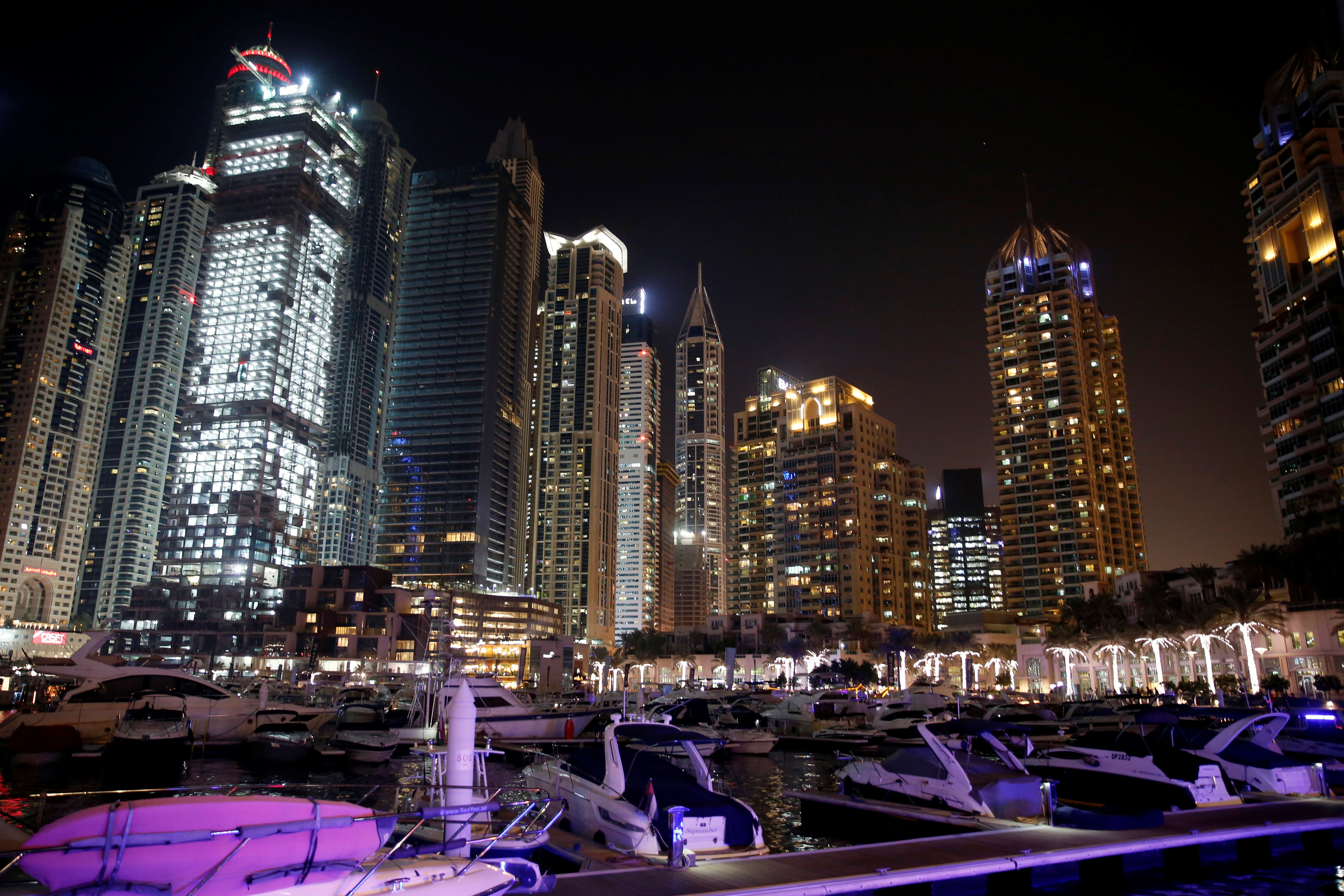 Yachts are seen at a dock at the Dubai Marina surrounded by high towers of hotels, banks and office buildings, in Dubai.
