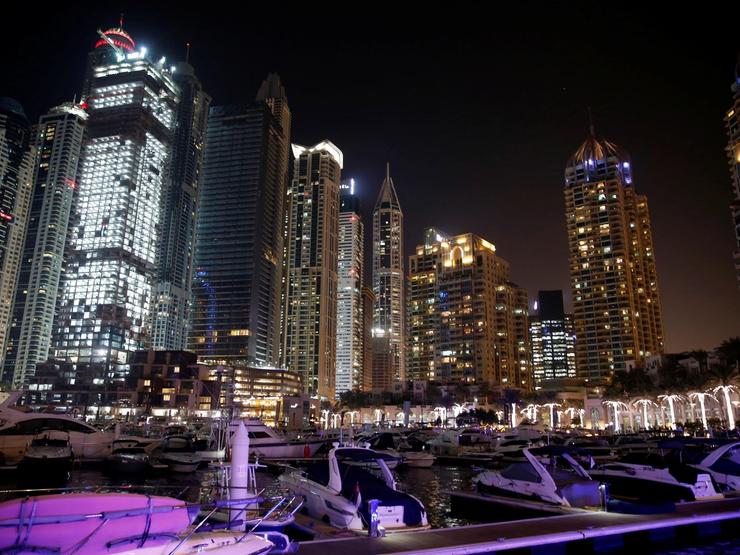 Yachts are seen at a dock at the Dubai Marina surrounded by high towers of hotels, banks and office buildings, in Dubai.