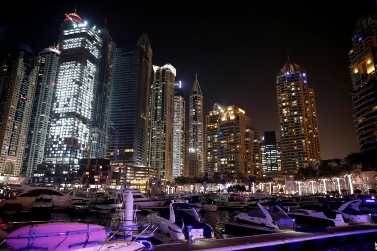 Yachts are seen at a dock at the Dubai Marina surrounded by high towers of hotels, banks and office buildings, in Dubai.