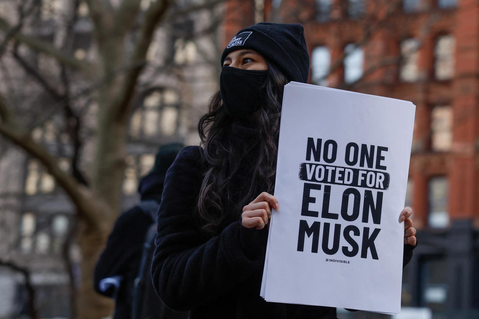 Protestor holding anti-Musk sign.