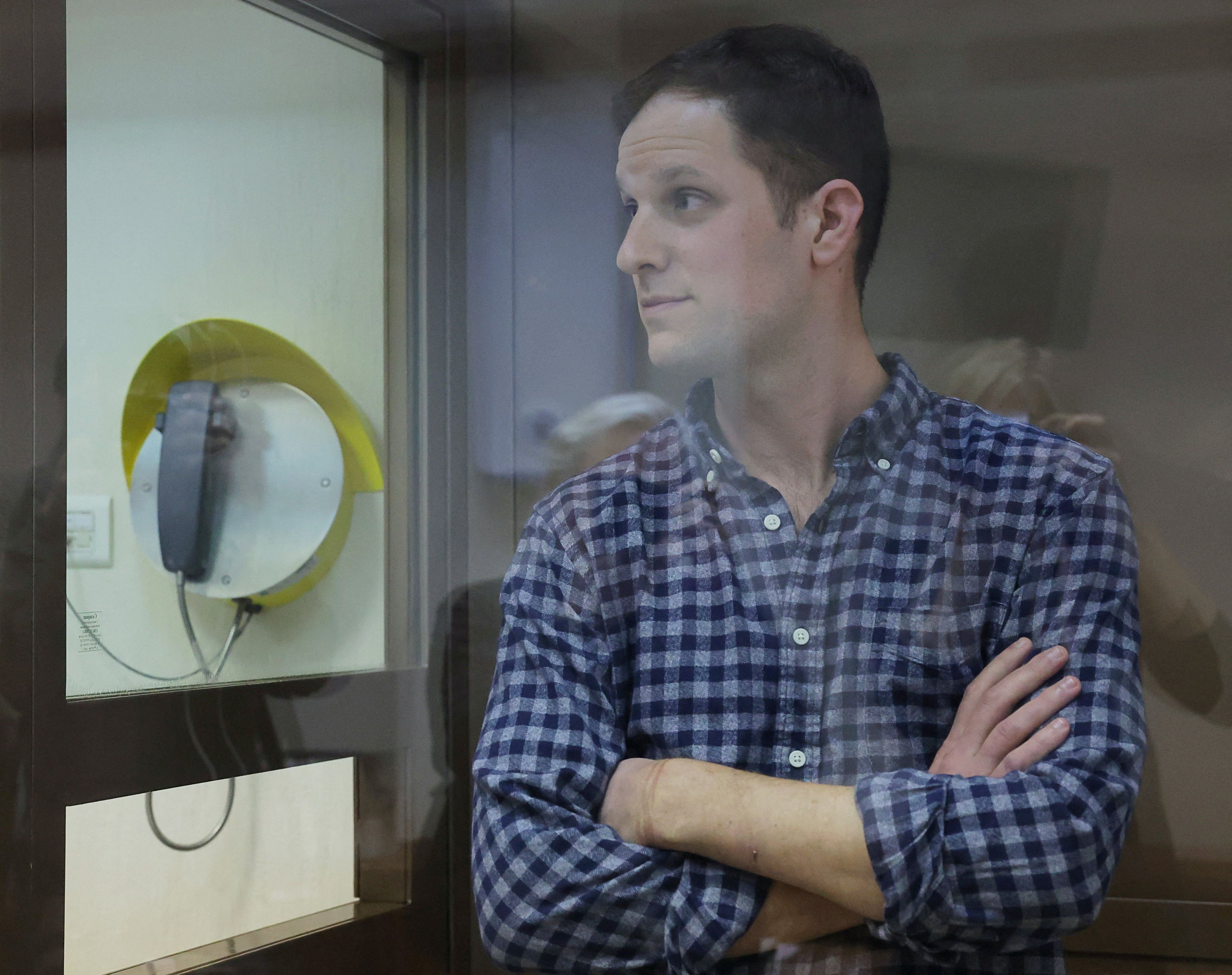 Wall Street Journal reporter Evan Gershkovich, who was detained in March while on a reporting trip and charged with espionage, stands behind a glass wall of an enclosure for defendants before a court hearing to consider an appeal against his detention, in Moscow, Russia April 18, 2023. REUTERS/Evgenia Novozhenina