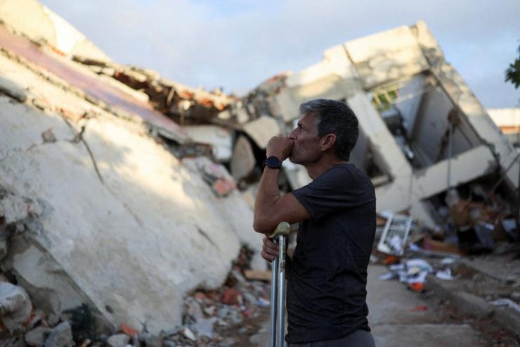 A man looks on at debris in Venezuela.