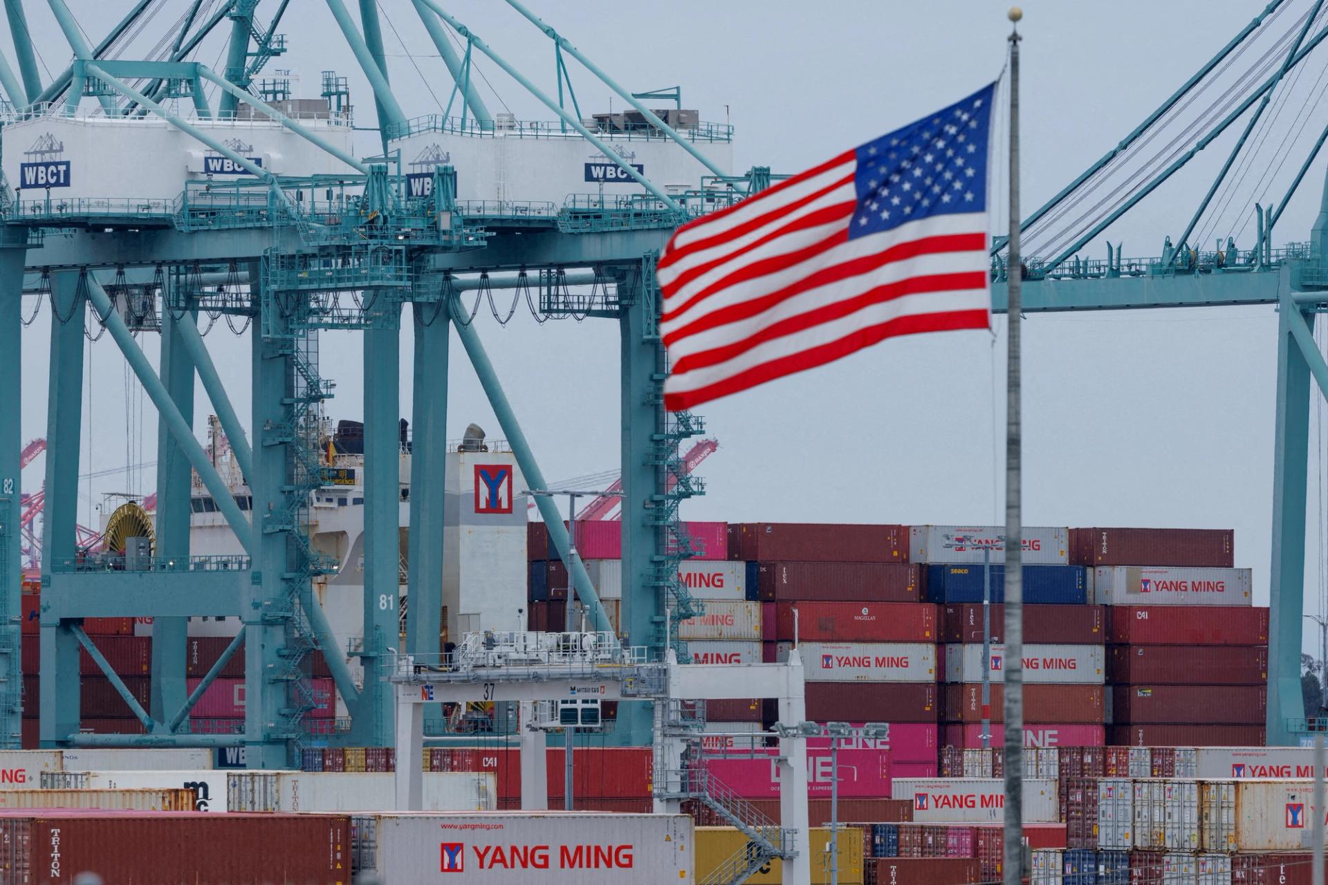 A U.S. flag flutters near shipping containers. 