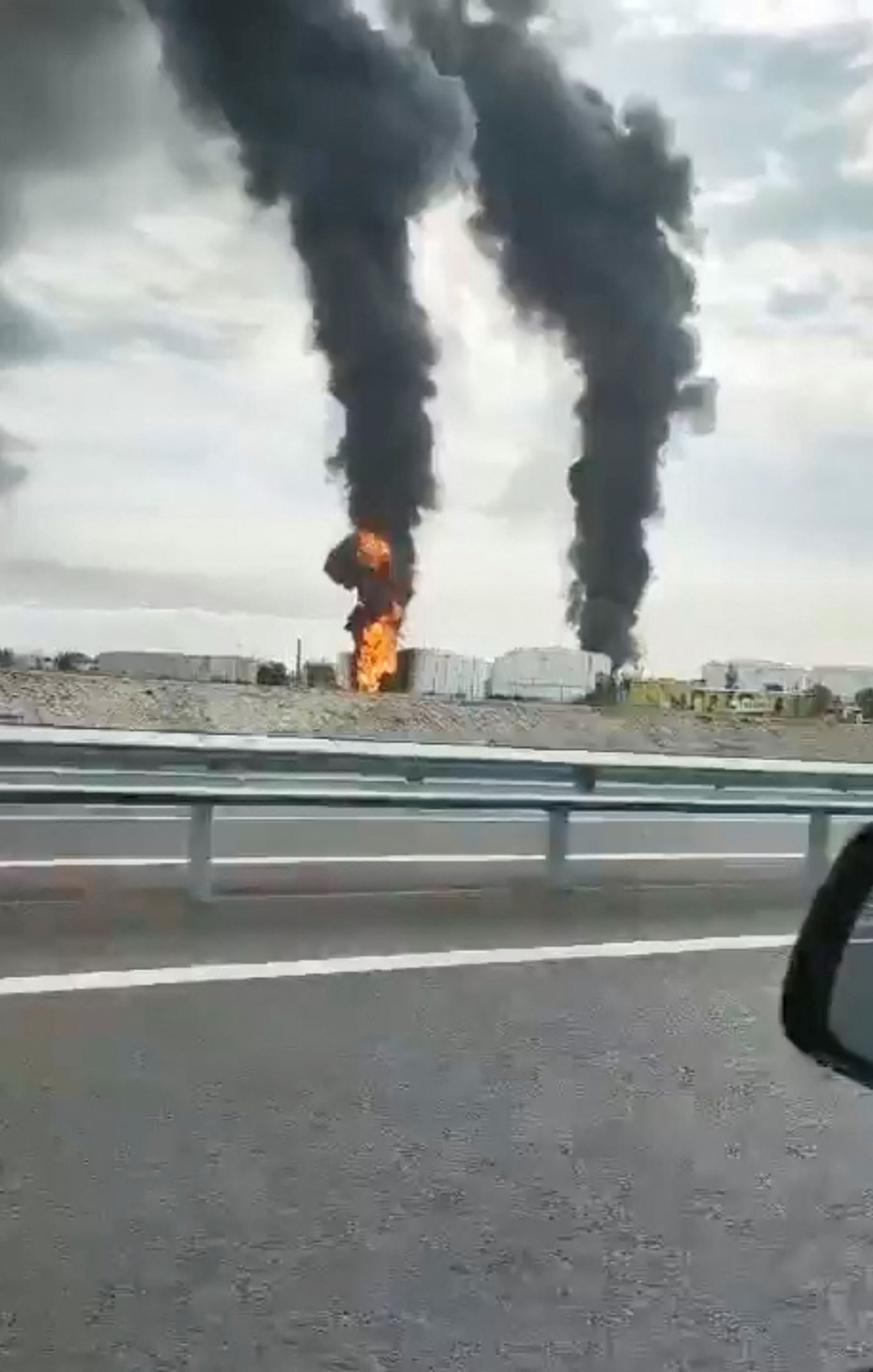 Footage taken from a moving vehicle shows a fire at an oil depot in Feodosia, Crimea, on the day the Ukrainian military said the energy facility was targeted.