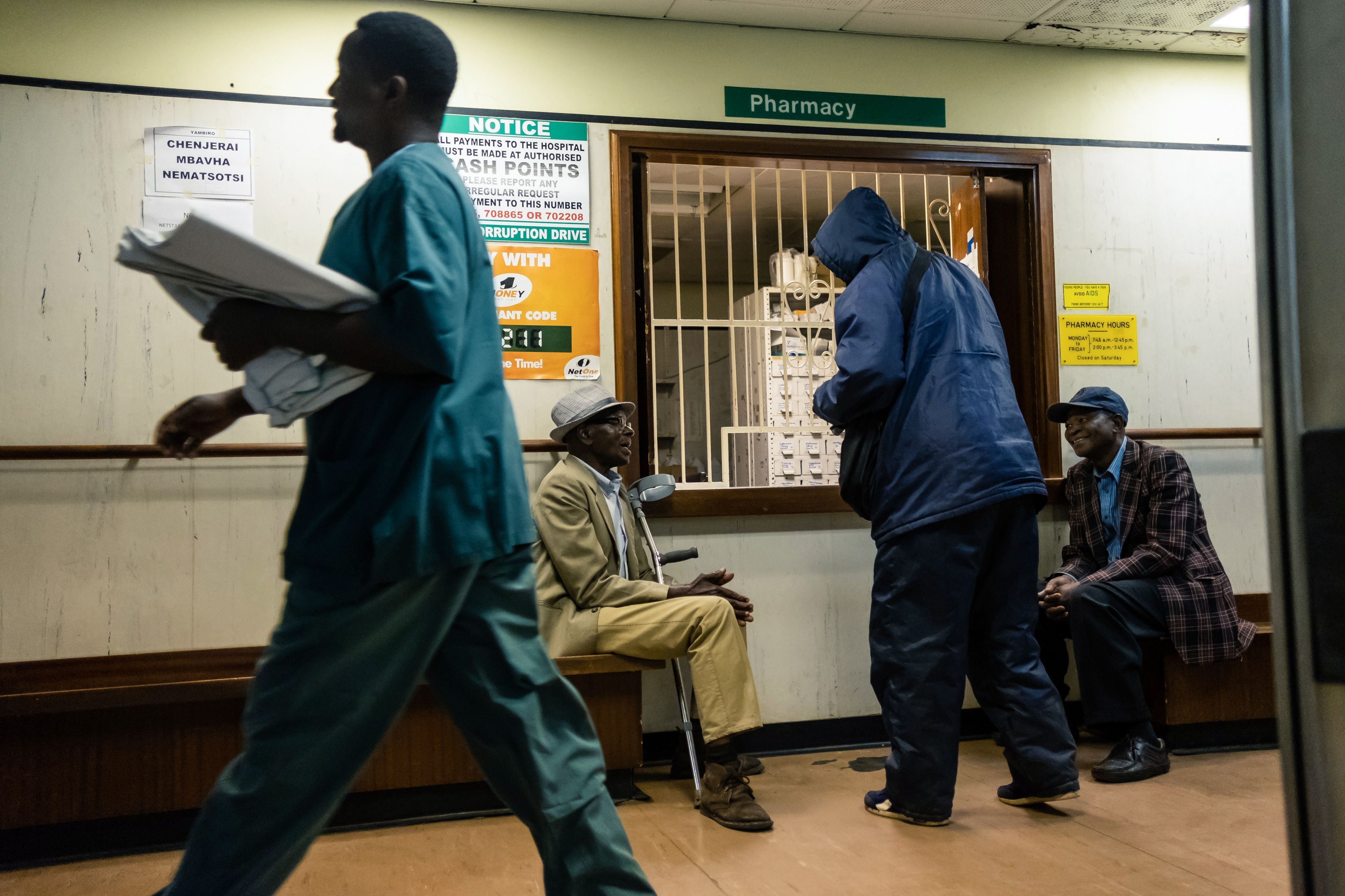 Elderly men wait for medicines at a pharmacy at Parirenyatwa hospital in Harare.