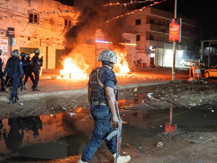 Police officers patrol near burning barricades as residents protest against power and water cuts in Banjul, Gambia, September 8, 2026.