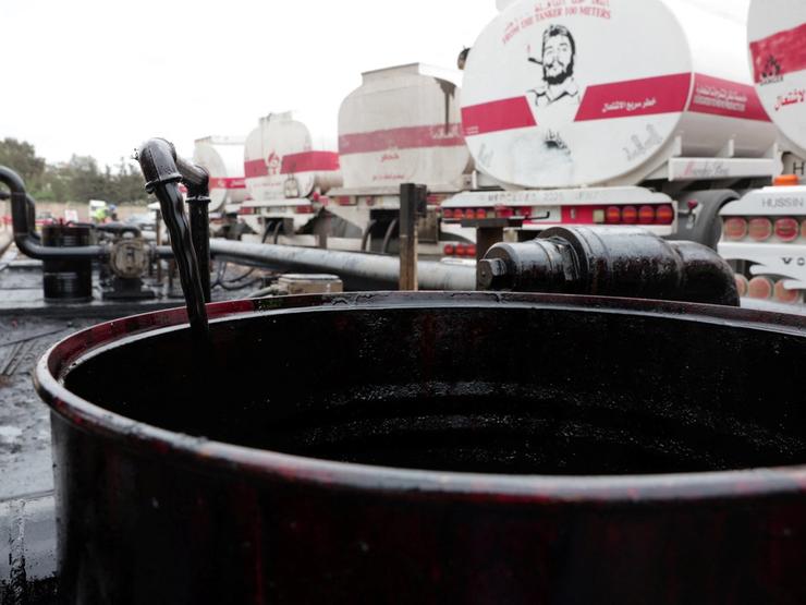 A barrel being filled with oil.