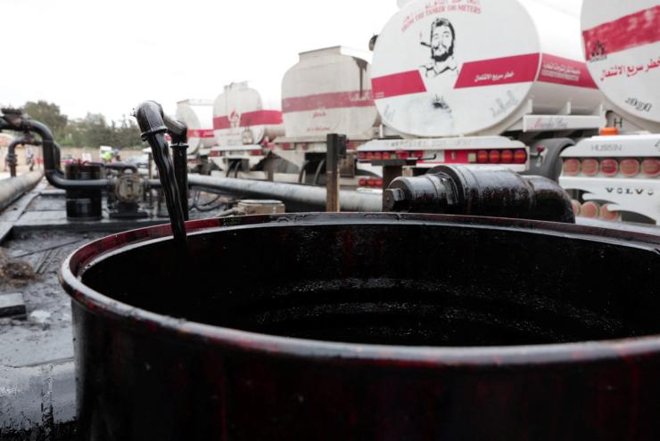 A barrel being filled with oil.