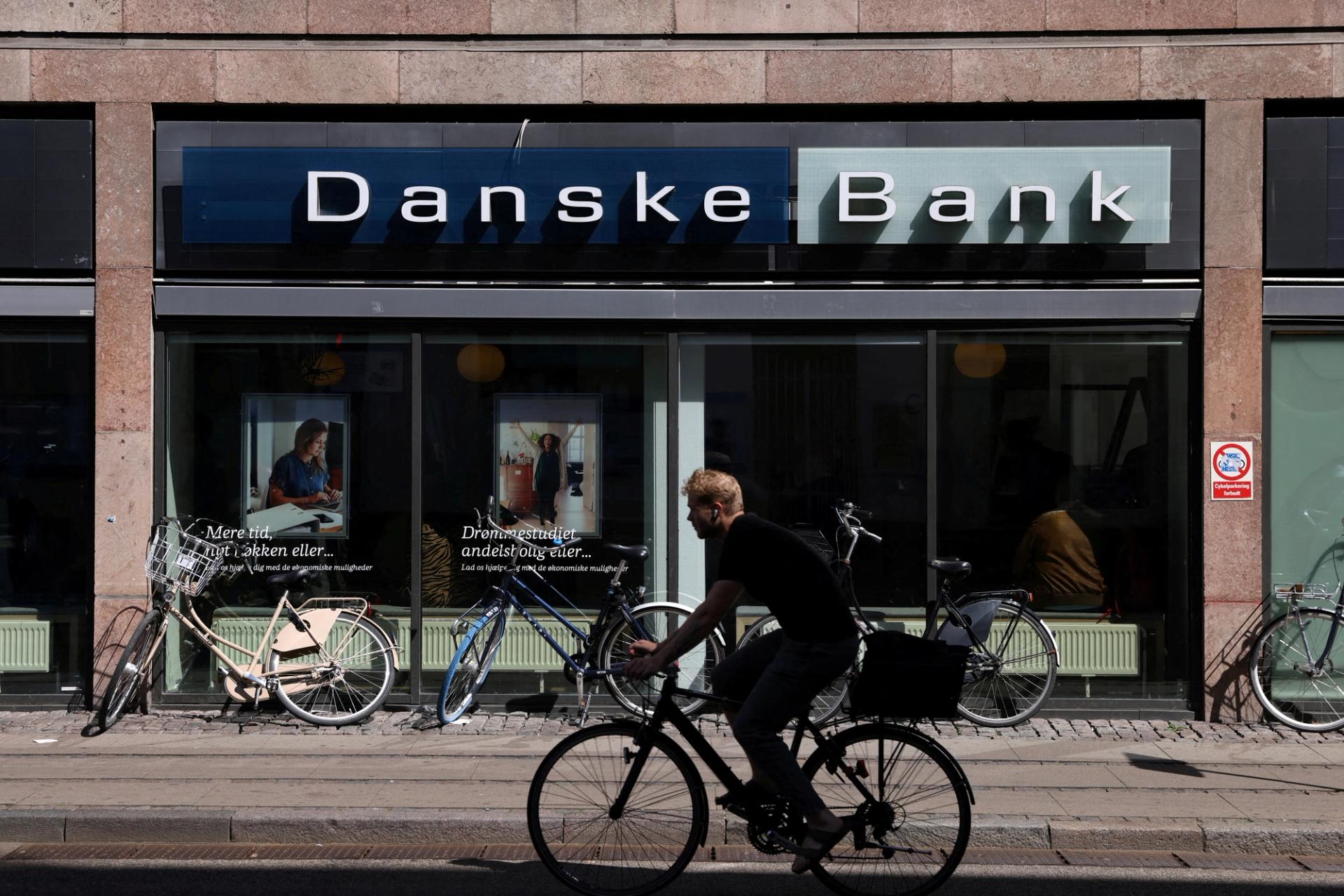 A person rides a bicycle past a Danske Bank branch in Copenhagen, Denmark.