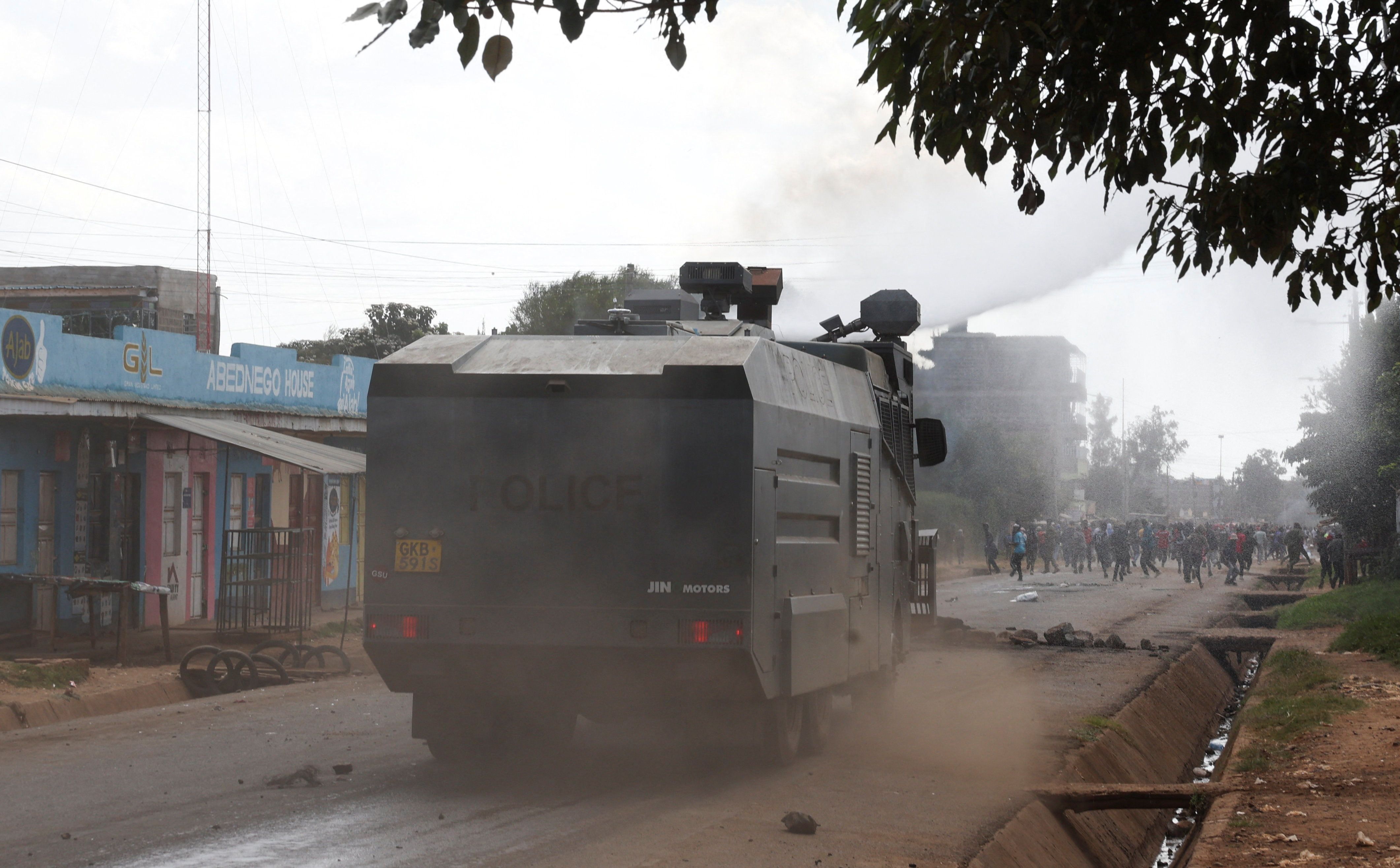 Riot police officers use a water cannon to disperse demonstrators in a protest against a US-backed Ebola quarantine plan in Kenya