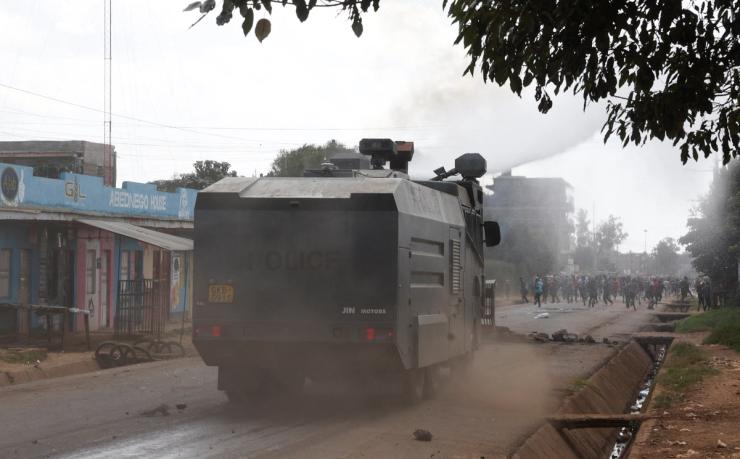 Riot police officers use a water cannon to disperse demonstrators in a protest against a US-backed Ebola quarantine plan in Kenya