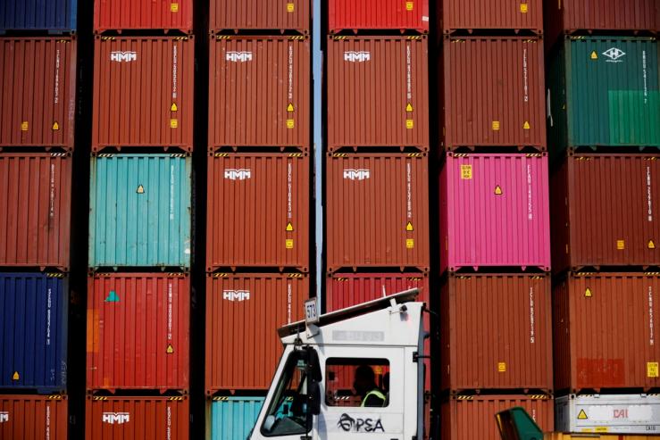 A truck driver works in front of shipping containers stacked up at Pusan Newport Terminal in Busan.