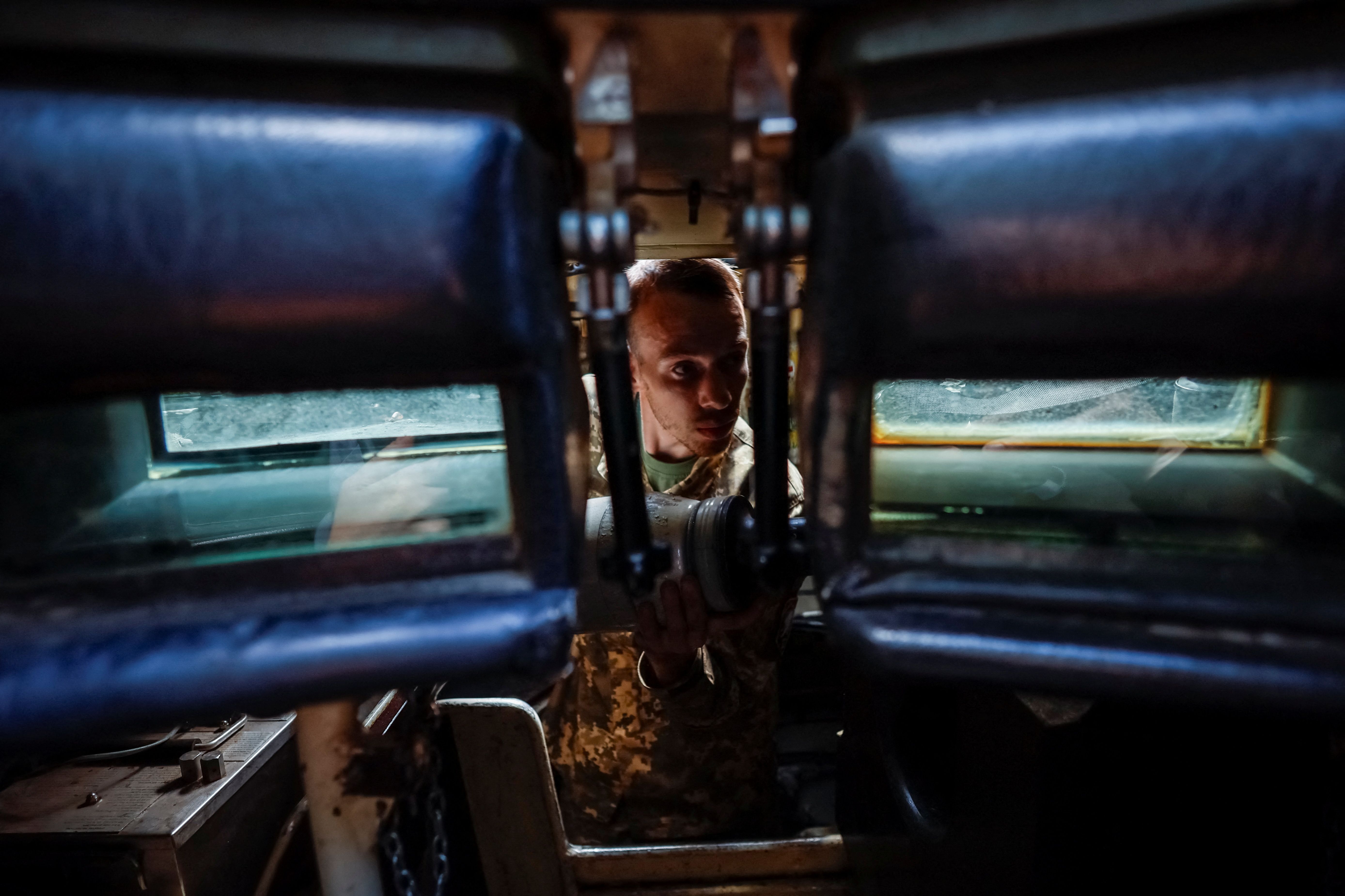 A Ukrainian soldier loads ammunition into a tank. 