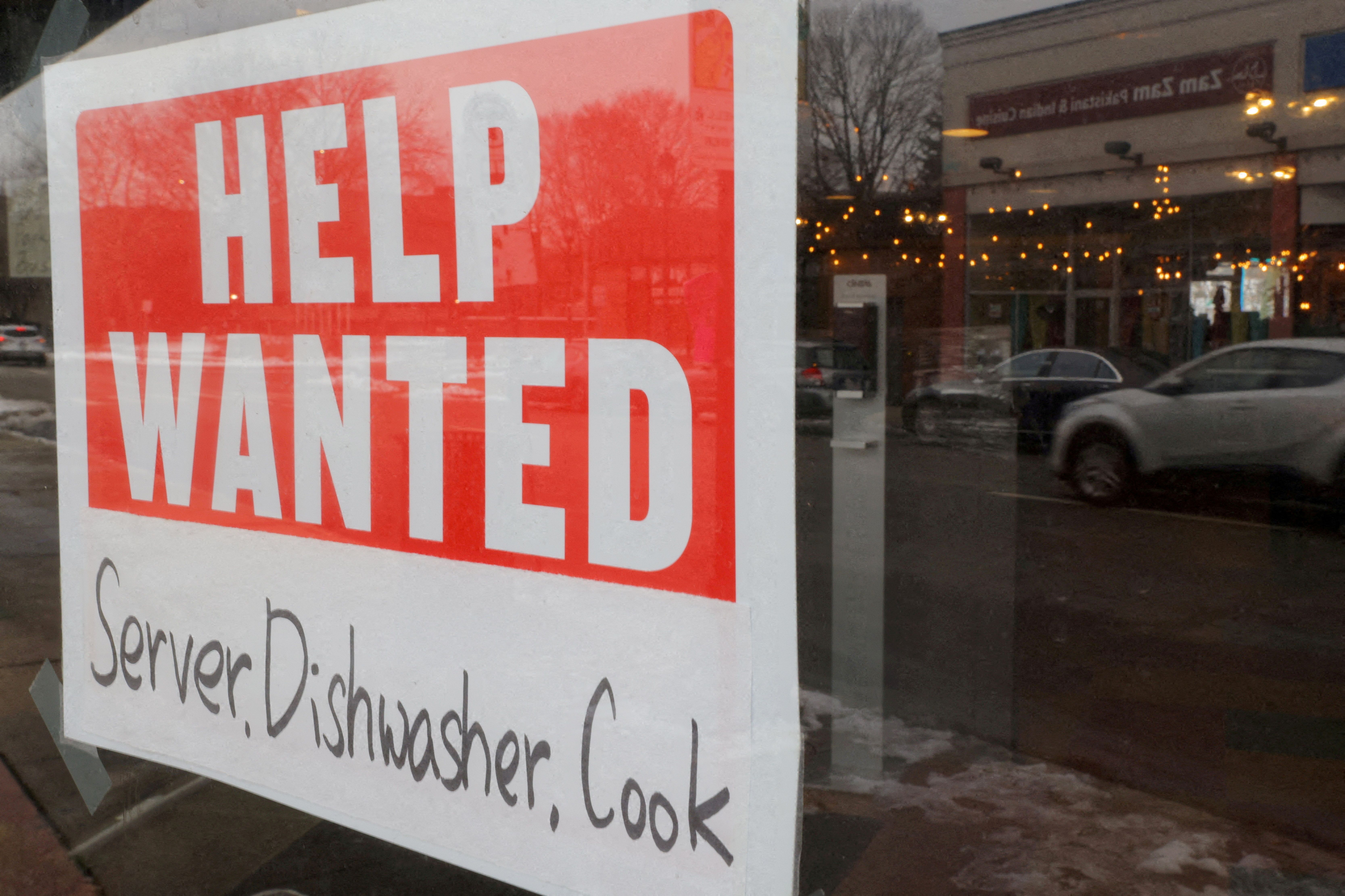 A “Help Wanted” sign hangs in restaurant window in Medford.