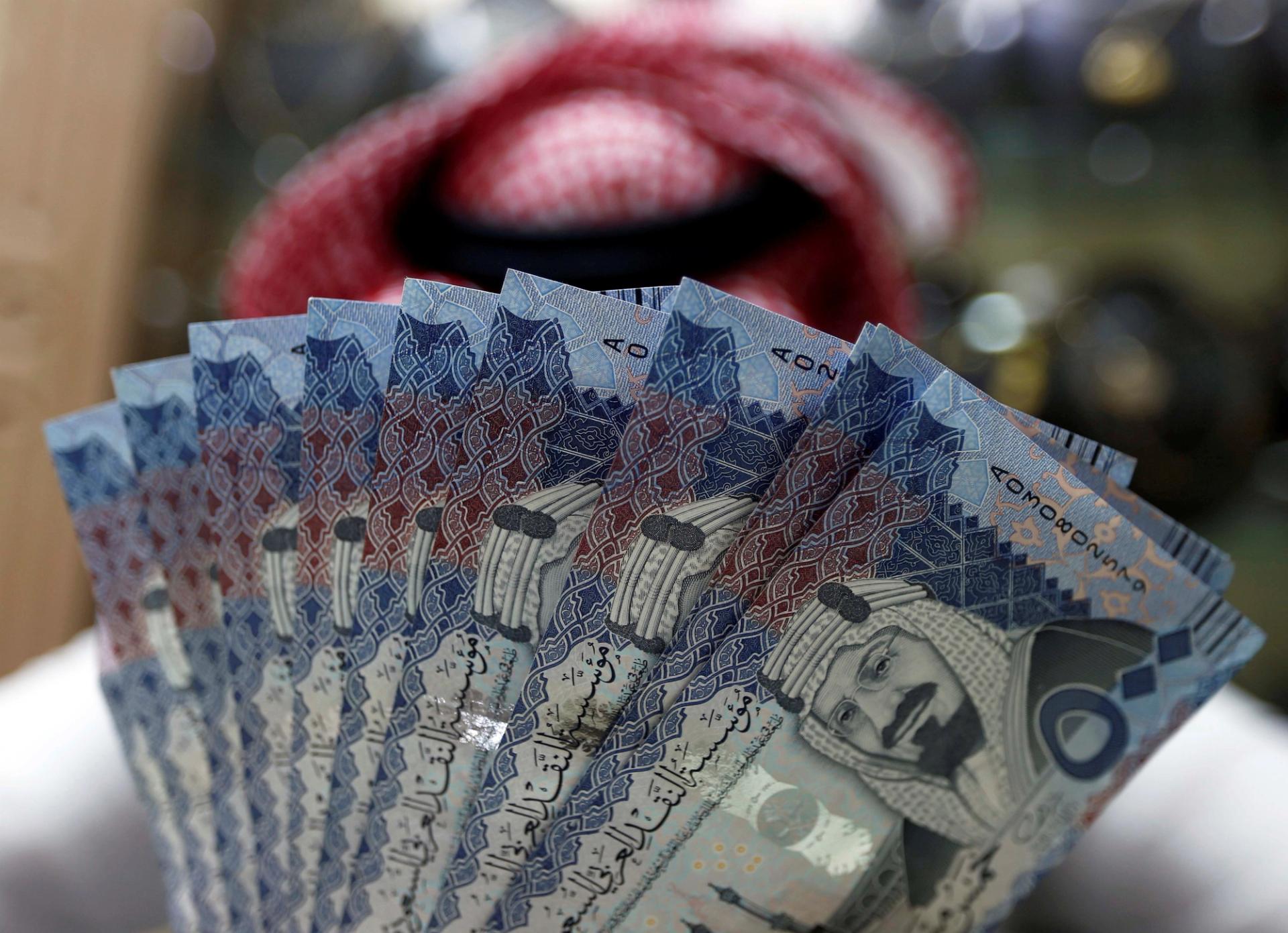 Saudi money changer displays Saudi Riyal banknotes at a currency exchange shop in Riyadh.