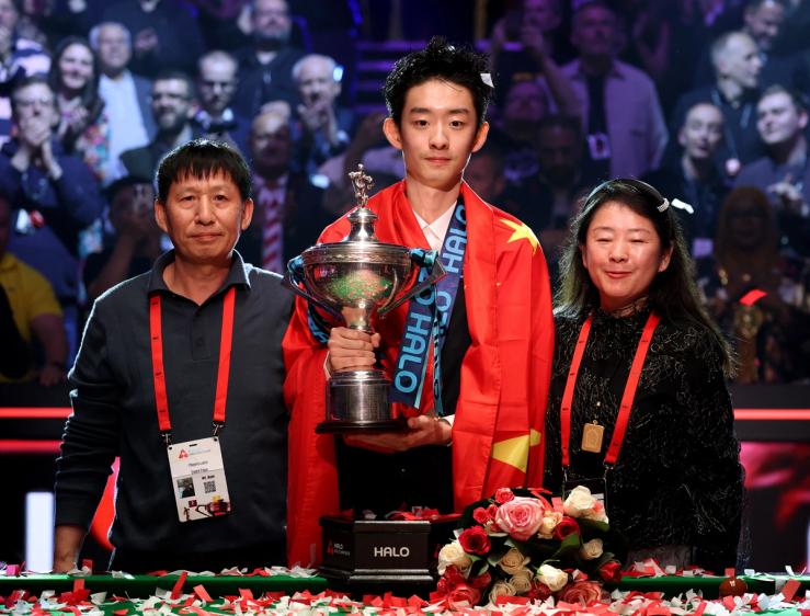 Chinaās Wu Yize poses with the trophy alongside his parents.