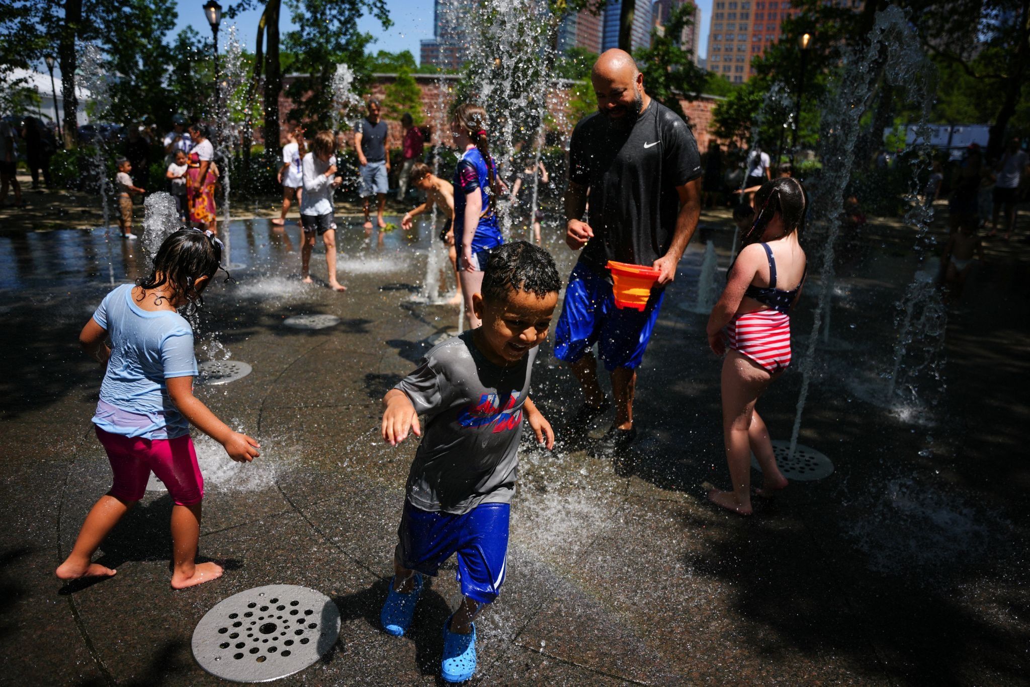 Children cool off as they play between fountains during a heatwave in New York. 