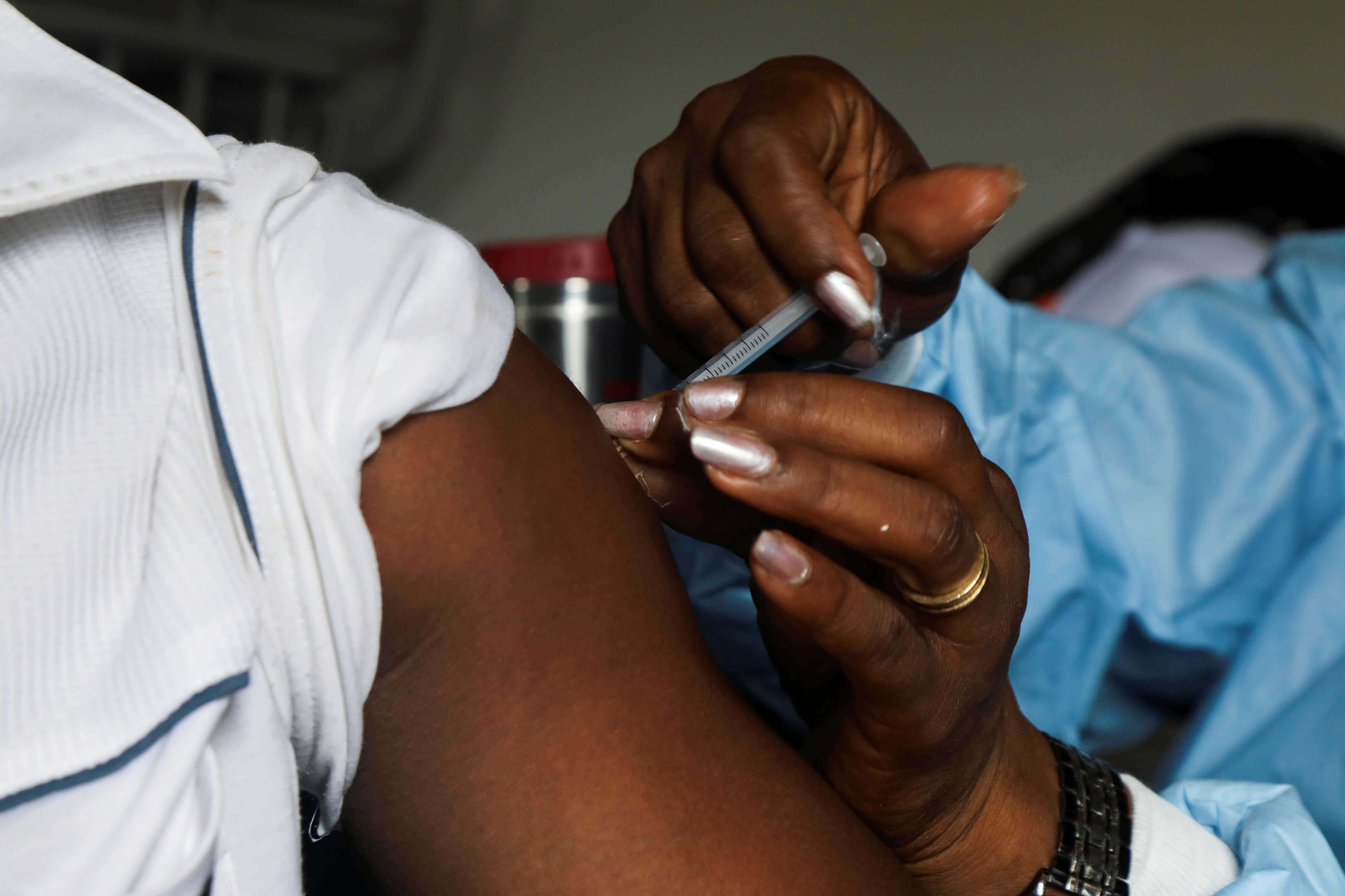 A man receives a vaccine against the coronavirus disease.