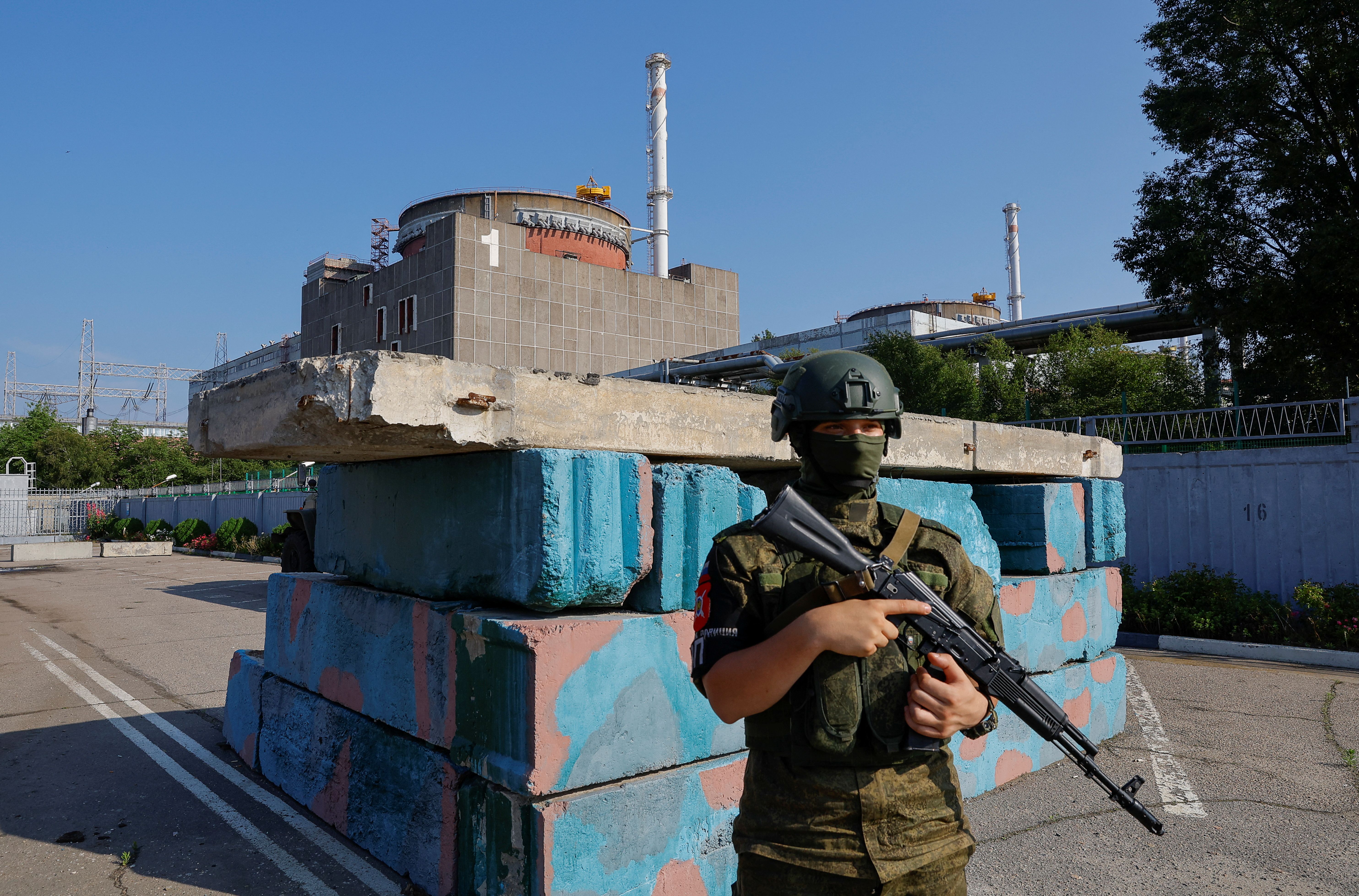 A Russian service member stands guard at a checkpoint near the Zaporizhzhia Nuclear Power Plant
