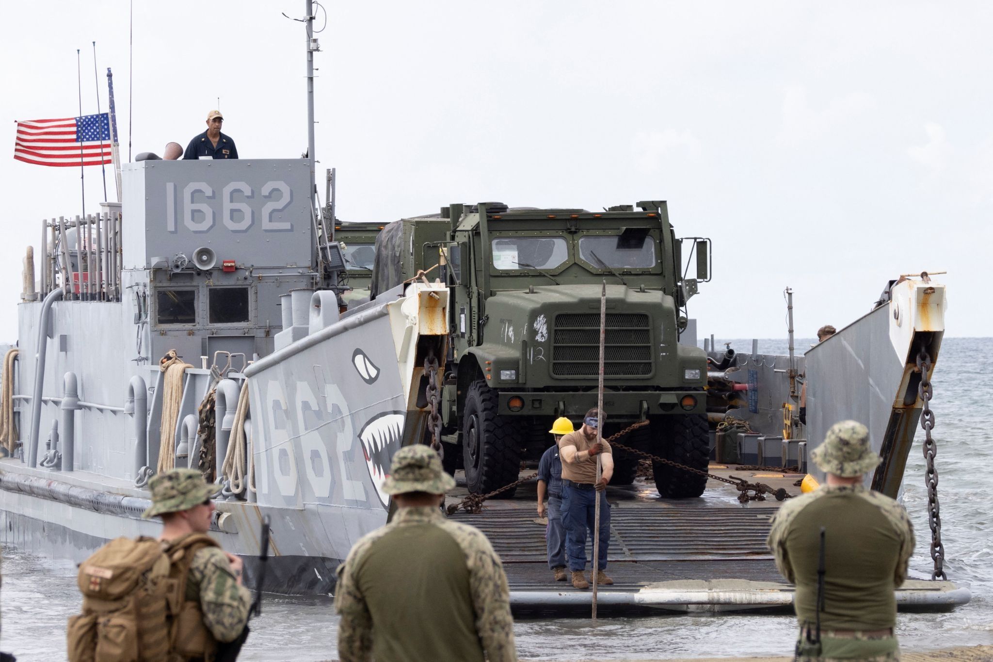	A U.S. Navy sailor uses a measuring stick to check water depth as the landing craft utility (LCU-1662) rests on the shore during training exercises in Arroyo