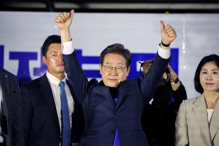 Lee Jae-myung greets his supporters in front of the National Assembly in Seoul.